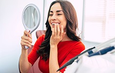 Woman smiling while looking at reflection in mirror