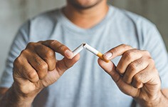 Closeup of man breaking cigarette