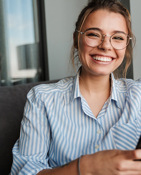 Woman in striped shirt with glasses smiling