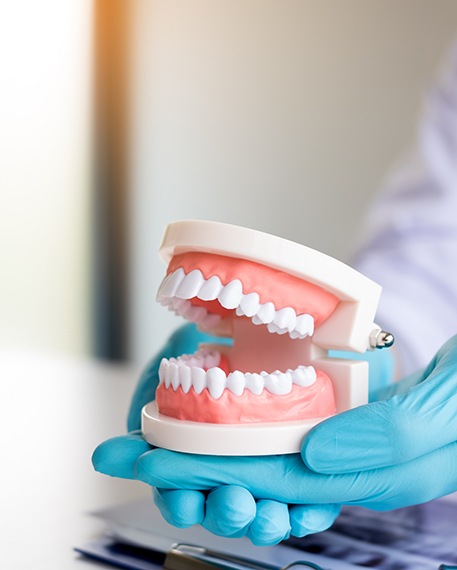 Patient holding model of teeth over X-ray