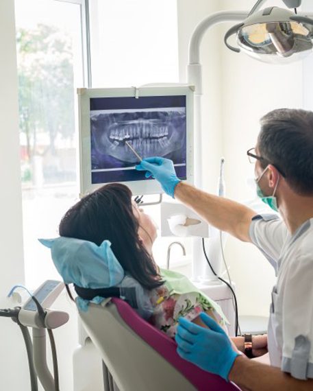 a dentist showing a patient their dental X-ray