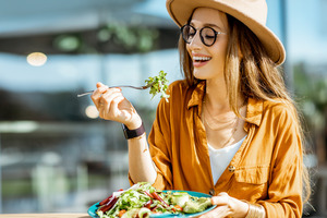 Woman sitting outside eating a salad